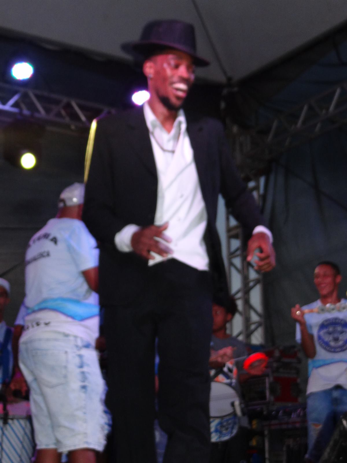 Dançarino de terno e chapéu no palco à noite