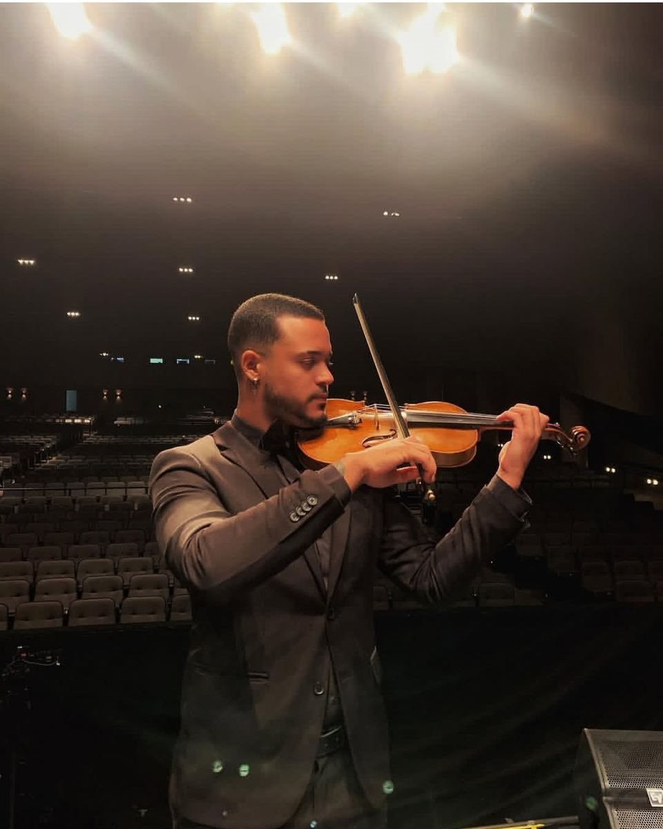 Violinista tocando sob as luzes do palco