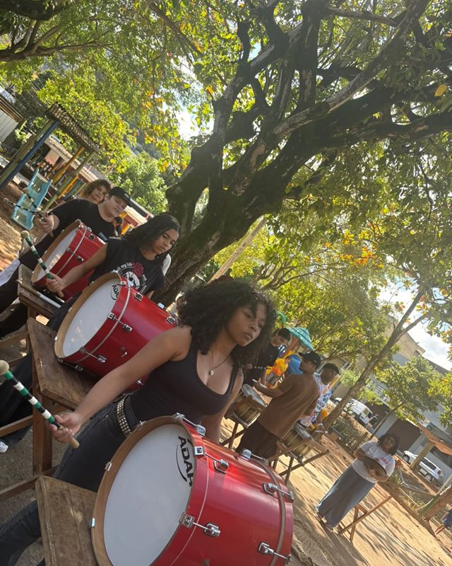 Jovens tocando tambores na oficina de percussÃ£o do Festival Alma de Artista, ao ar livre