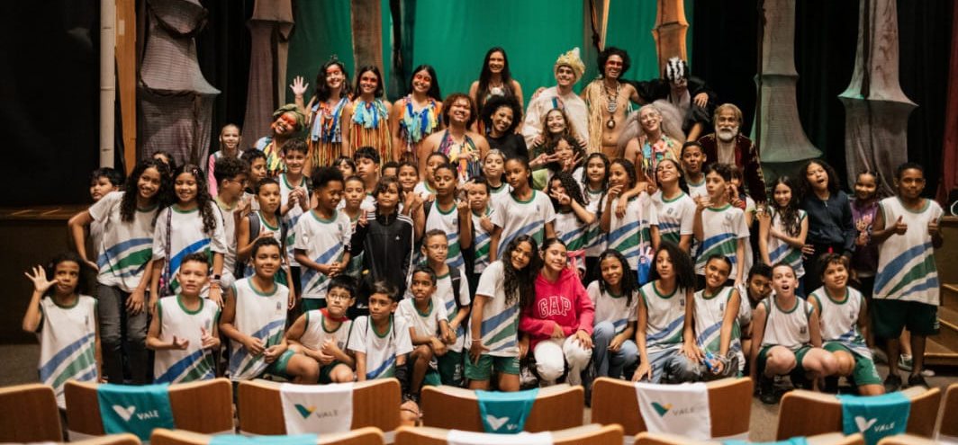 Turma de escola com o elenco no palco