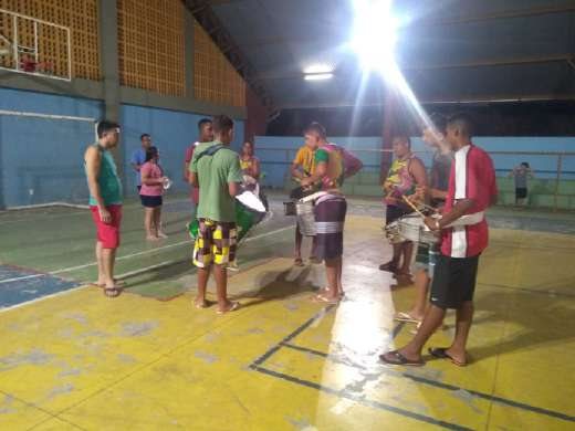 Alunos com instrumentos de percussão em uma quadra