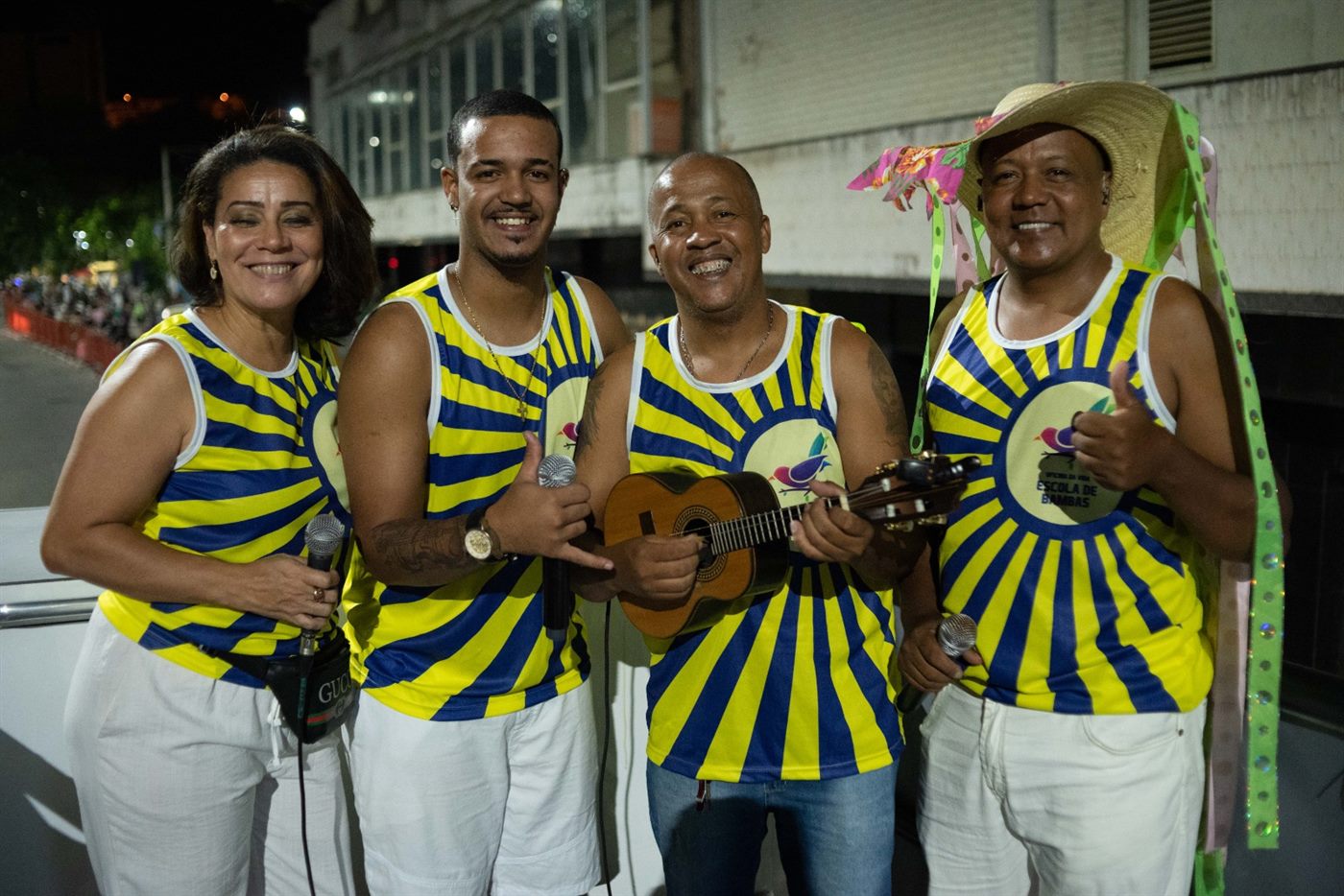 Sambistas com camisas listradas e instrumentos